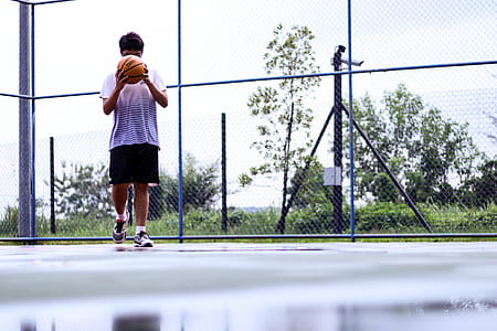 Man Holding Orange Basketball thumbnail