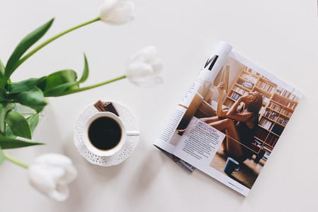 1 Teacup With Saucer and Magazine on White Surface thumbnail