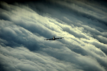white plane over white clouds thumbnail