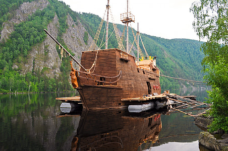 brown wooden ship on body of water at daytime thumbnail