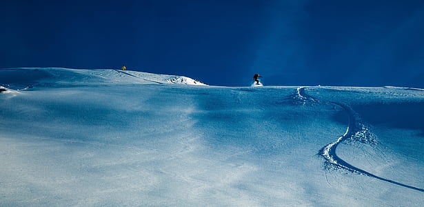 man on top of snowy hill during daytime thumbnail