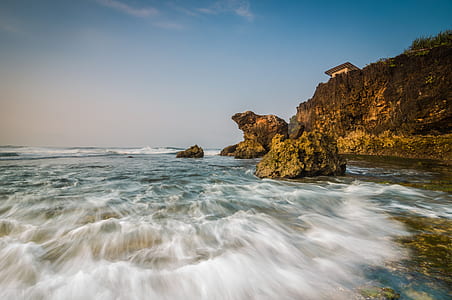 brown rock formation near body of water thumbnail