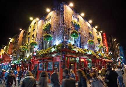 group of people walking on street in front of red lighted building thumbnail