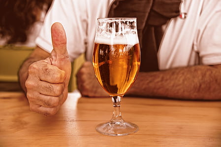 person gesturing thumbs up beside almost-filled cocktail glass thumbnail