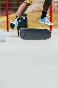 man playing with his skateboard up in the air during daytime thumbnail