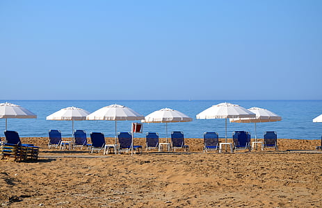blue lounge chairs near shore thumbnail