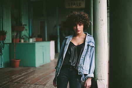 woman wearing blue jacket leaning against post thumbnail