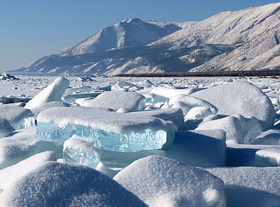 snow covered field and mountain during daytime thumbnail