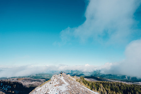 in distant photo of man on mountain peak thumbnail