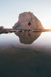 man standing near rock formation thumbnail