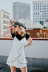 woman in white and black polka-dot dress holding her cap during daytime thumbnail