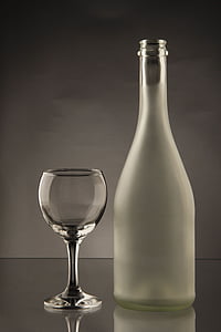 clear glass bottle besides wine glass thumbnail