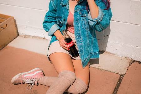 woman sitting on floor while holding Coca-Cola bottle thumbnail