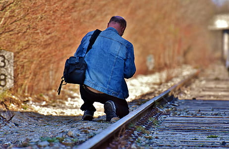 man kneeling near the railway thumbnail