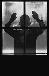 silhouette of toddler standing in front of window thumbnail