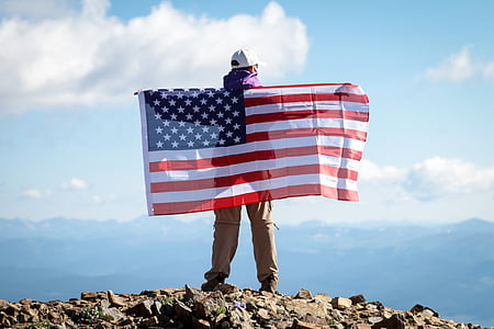 man holding U.S.A flag standing on mountain thumbnail