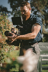 man holding video camera while taking photo thumbnail