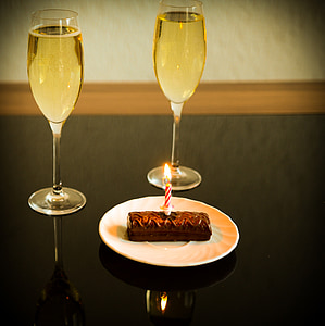 cake with candle beside wine glasses thumbnail