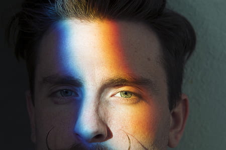man's face with blue, white, and orange lights thumbnail