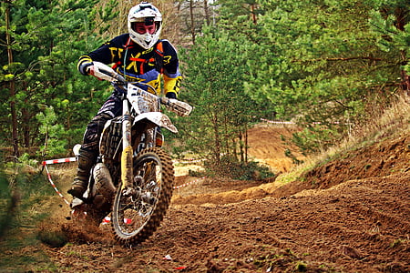 man riding motocross dirt bike on dirt track in forest thumbnail