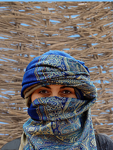 close up photo of a person wearing blue and green floral scarf thumbnail