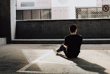 man wearing black shirt and sitting on the ground thumbnail