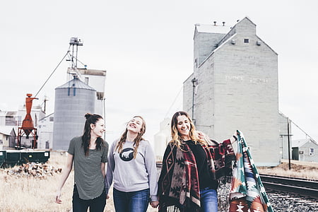 four women walking near white building at daytime thumbnail