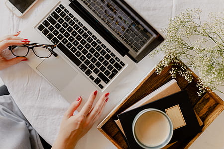 A woman works at a desk with a laptop and a cup of coffee thumbnail