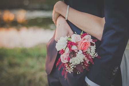 woman hugging a man while holding flower bouquet thumbnail
