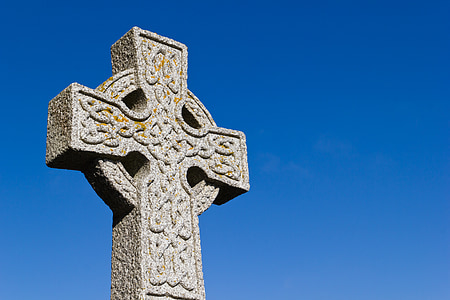 low angle of gray cross under blue sky thumbnail