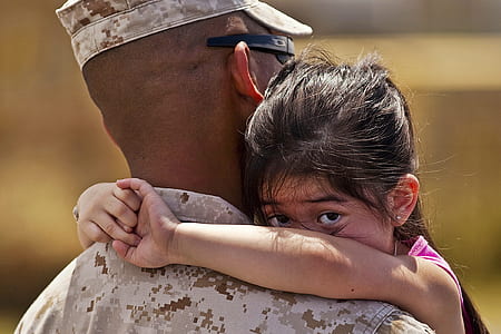 soldier carrying girl wearing pink tank top during daytime thumbnail