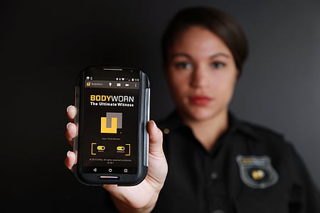 woman holding smartphone displaying bodyworn thumbnail