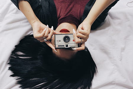 woman holding gray cameaa thumbnail