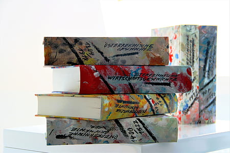 pile of four assorted-title books on white surface thumbnail