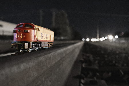 selective focus photograph of red train toy on rail thumbnail