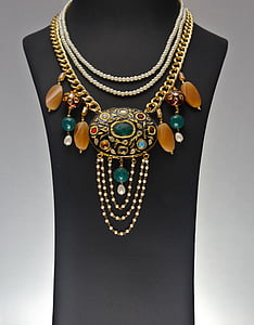 woman's gold-colored fashion necklace on female torso mannequin thumbnail