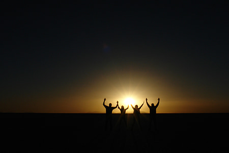 silhouette of four person raising hand during sunset thumbnail