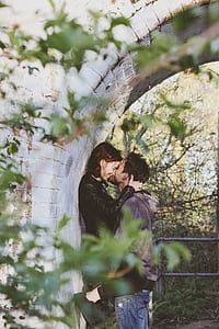 couple under white concrete arch thumbnail
