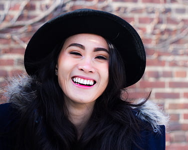 woman smiling near wall during daytime thumbnail