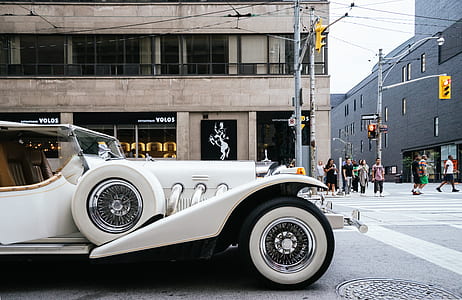 White Vehicle Near Gray Lamp Post and Brown Building Structure thumbnail