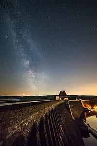 brown house near dam under stars thumbnail