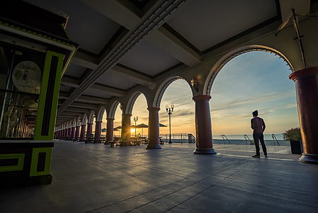 man standing near brown concrete post thumbnail