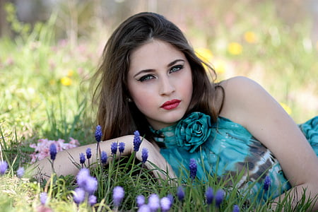 woman wearing teal and gray halter-top lying on purple flower field during daytime thumbnail