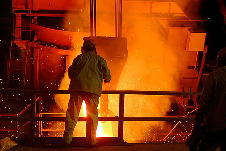 person in green shirt and pants standing near fire thumbnail