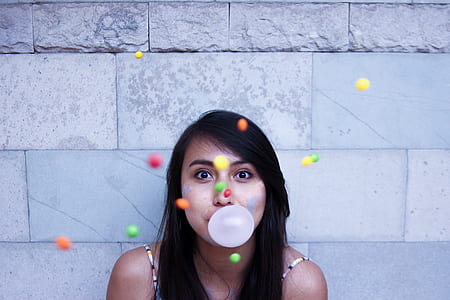 woman with bubble gum balloon near wall thumbnail