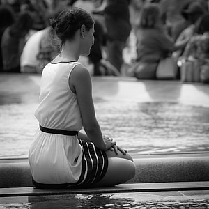 grayscale photography of woman in white sleeveless dress sitting on wooden surface thumbnail