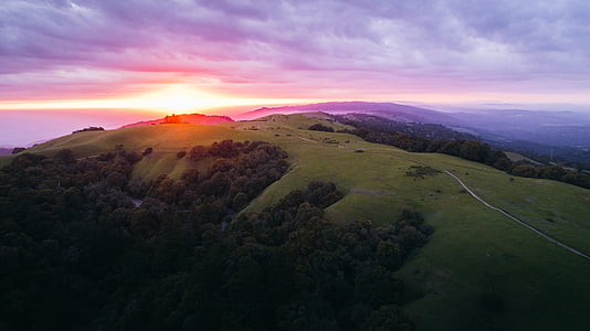 aerial photo of hills with green trees during golden hour thumbnail