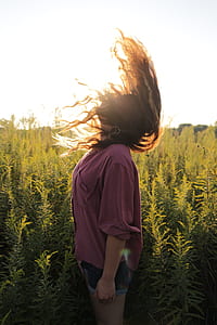woman in purple shirt surrounded by green plant lot thumbnail