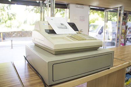 white cash register placed on wooden counter thumbnail