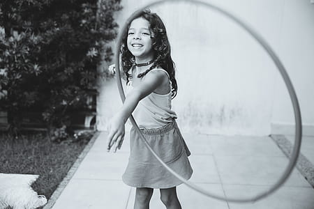 grayscale photo of girl playing hulahoop thumbnail
